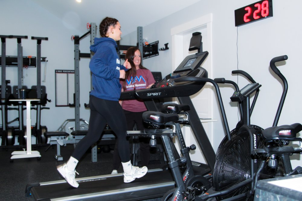 client on treadmill with personal trainer