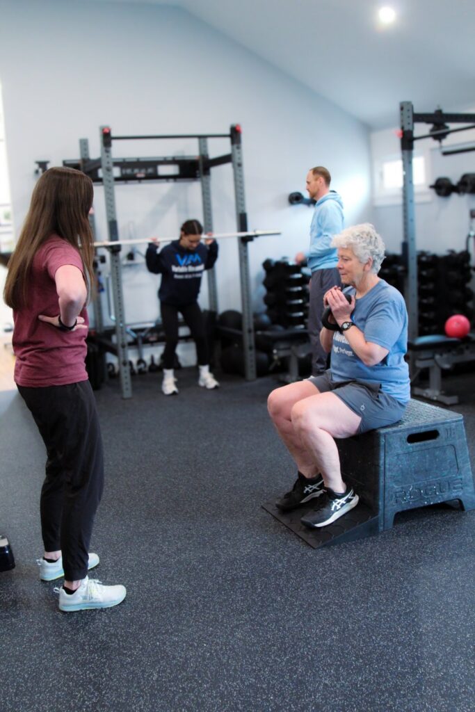 two personal trainers working with clients in the gym