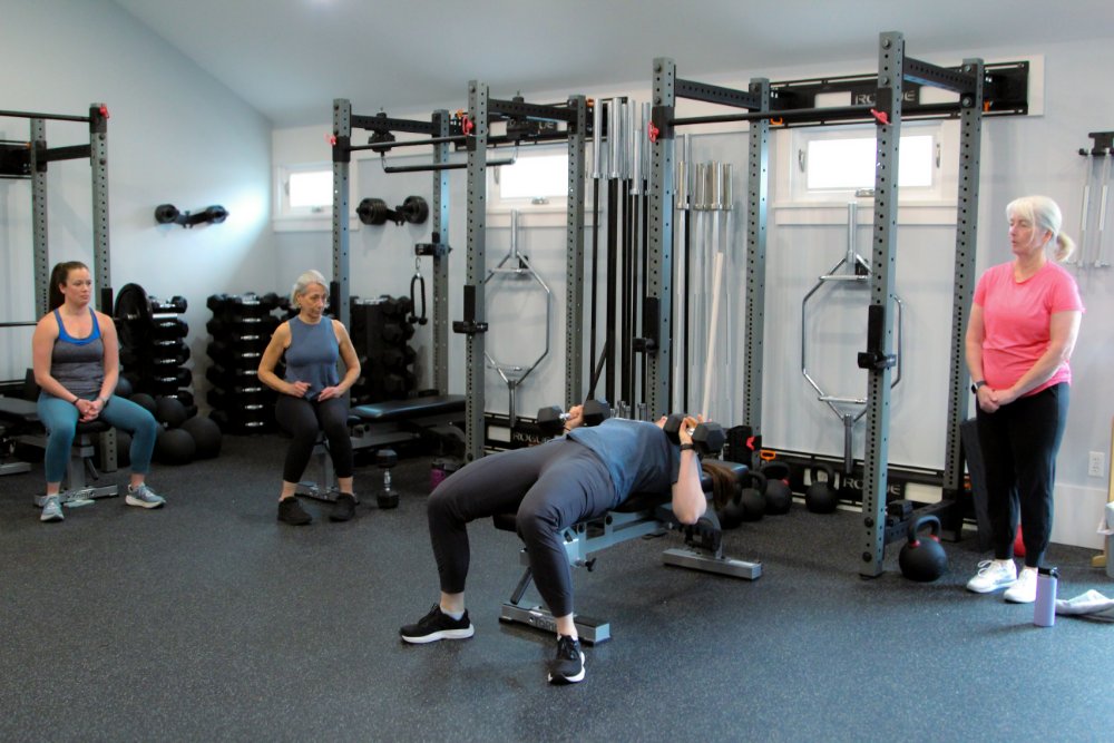 Group session, coach demonstrating how to use weights safely